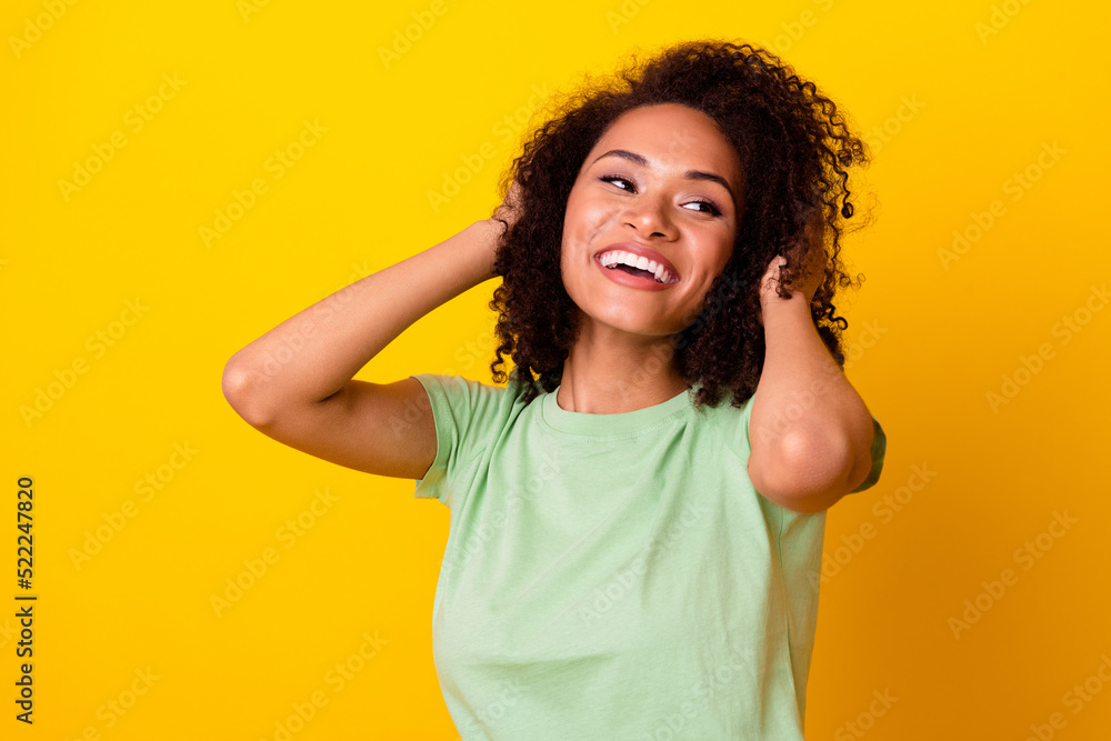 Photo of sweet adorable lady wear green t-shirt looking empty space arms hairdo isolated yellow color background Photo of sweet adorable lady wear green t-shirt looking empty space arms hairdo isolated yellow color background