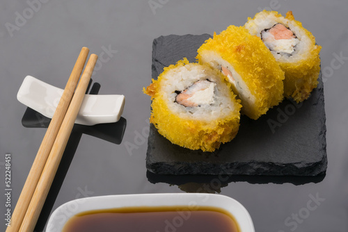 tempura roll with soy sauce, top view on a dark background