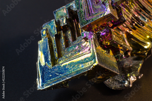 Bismuth bi close up on black surface.Interesting colour and shape crystal. Metal crystal