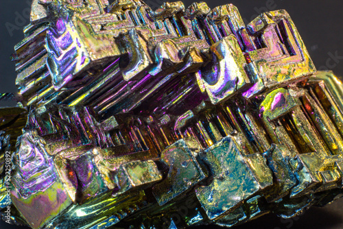 Bismuth bi close up on black surface.Interesting colour and shape crystal. Metal crystal