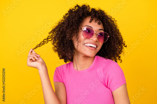 Photo of funny dreamy lady wear pink top dark eyewear holding curl looking empty space isolated yellow color background