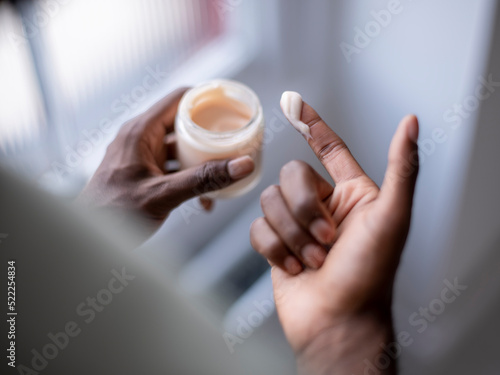 Close-up of person holding jar of moisturizer