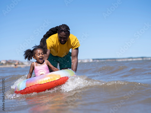 Father with daughter (2-3) playing in sea © Cultura Creative