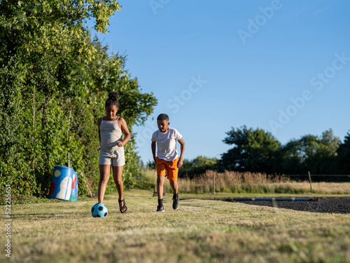 Siblings (8-9, 10-11) playing soccer © Cultura Creative