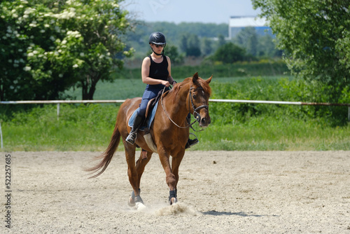 The girl with helmet riding a stud at a riding school