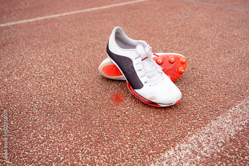 Pair of running spikes on running track photo