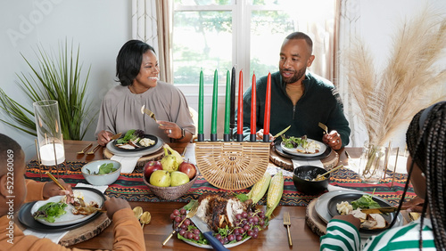 Family with children (8-9, 12-13) eating Kwanzaa meal photo