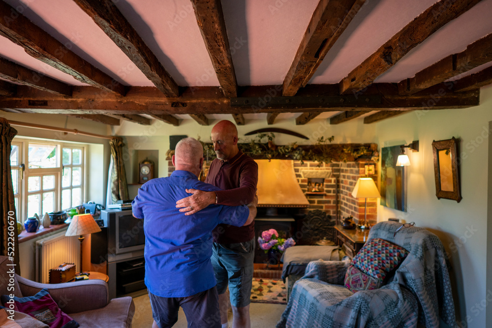 Senior male couple playing dancing at home