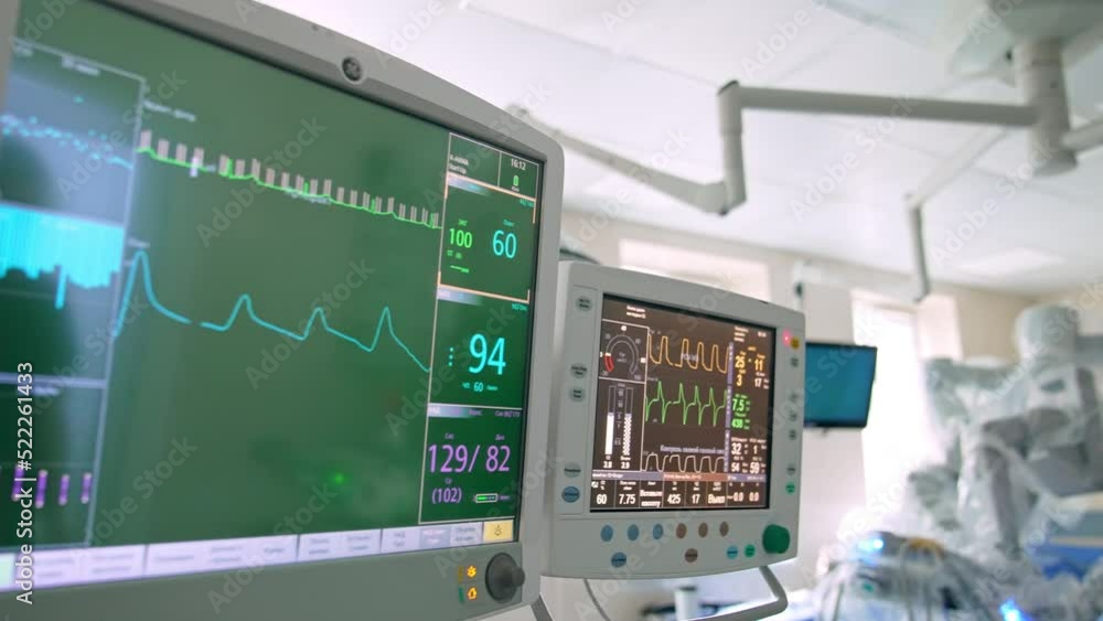 Monitors working in the surgery room during surgical operation. Close up. Surgeon working at the backdrop near Da Vinci robot. Monitors working in the surgery room during surgical operation. Close up. Surgeon working at the backdrop near Da Vinci robot.