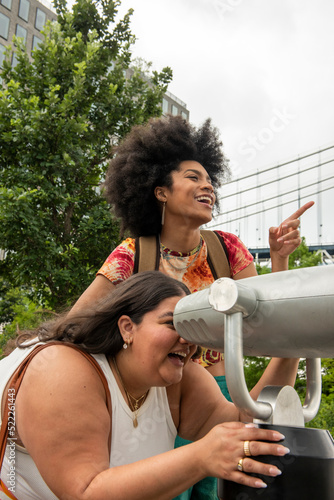 USA, New York City, Two women using telescope for sightseeing