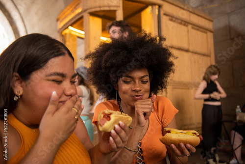 Two young women eating street food