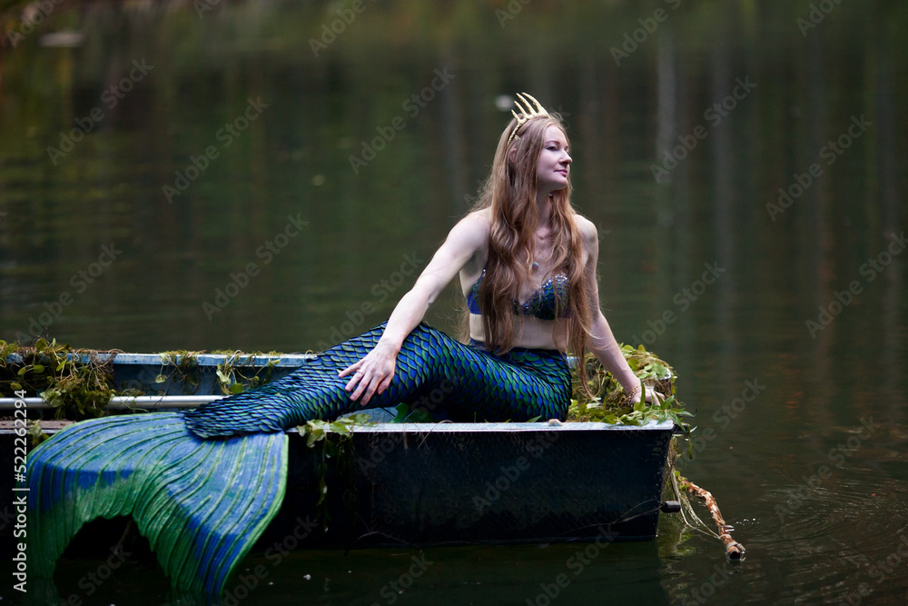 Mermaid story. The little mermaid sits in a boat. Mermaid at