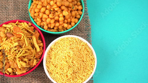 Indian Snacks, Traditional Indian deep fried salty dish called chivda or mixture or farsan made of gram flour and mixed with dry fruits and roasted nuts with salt, pepper, pulses, spice and green peas photo