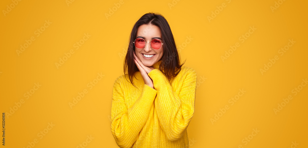 Excited stylish young ethnic woman smiling at camera in yellow studio Excited stylish young ethnic woman smiling at camera in yellow studio