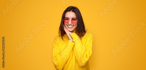 Excited stylish young ethnic woman smiling at camera in yellow studio © kegfire