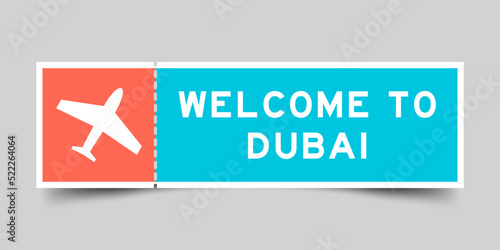 Orange and blue color ticket with plane icon and word welcome to dubai on gray background