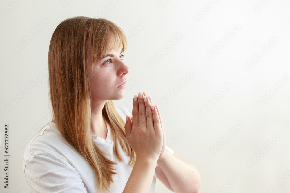 young woman prays, says a prayer on a white background young woman prays, says a prayer on a white background