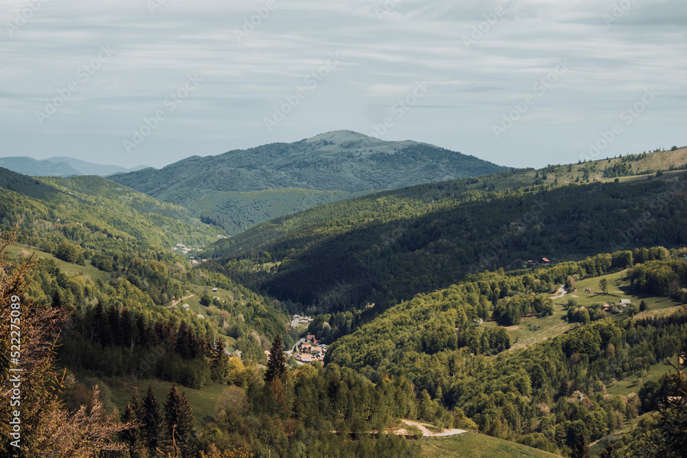 Landscape with small mountain villages between trees at the bottom of the hills. True rural life in the wild