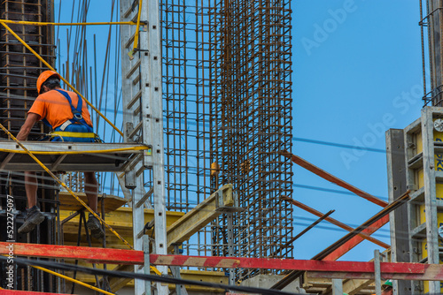 Construction worker sitting on scaffolding taking a break while wearing a safety helmet