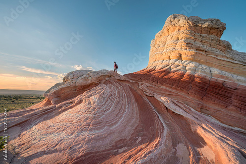 hiker standing on top of interesting rocks at sunset