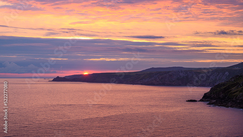 Cornish sunset over the sea with the land in shade