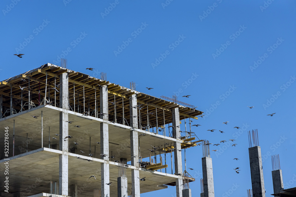 As part of construction a multi-story apartment building, work is in progress along the building perimeter As part of construction a multi-story apartment building, work is in progress along the building perimeter