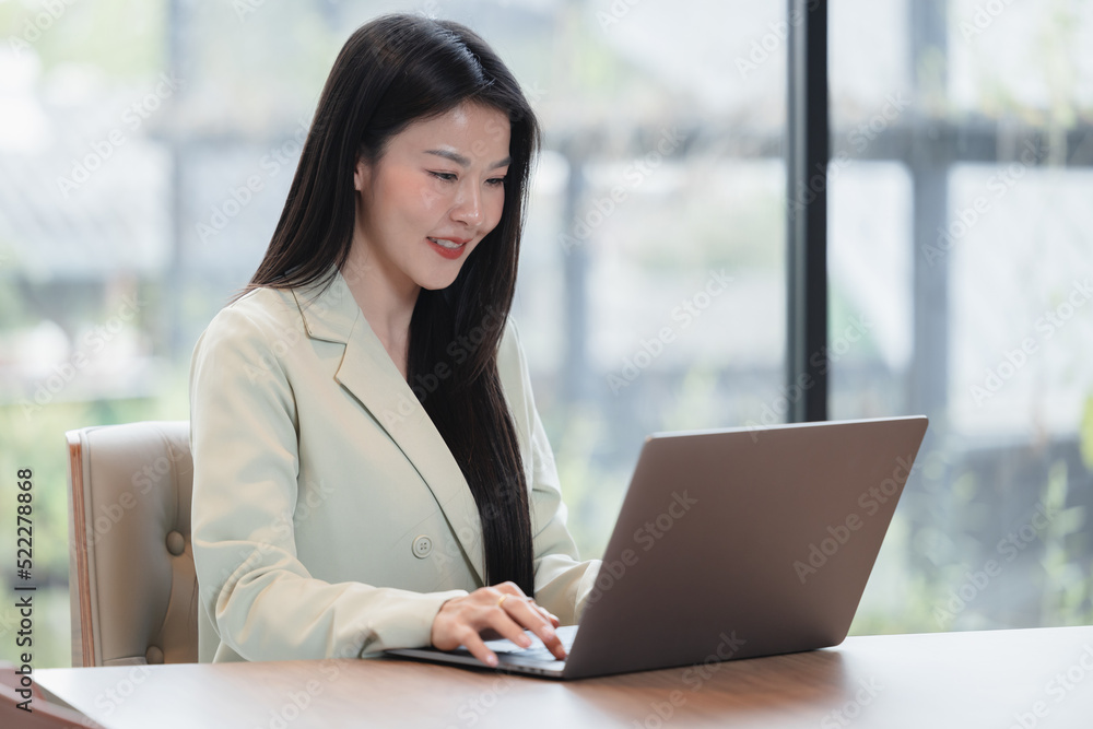 Asian young business woman working, using computer laptop at the office, Beautiful woman happy face smiling and looking at the computer laptop ,Business concept. Asian young business woman working, using computer laptop at the office, Beautiful woman happy face smiling and looking at the computer laptop ,Business concept.