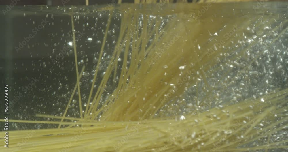 spaghetti de pâtes non cuites à l'eau. Des spaghettis sous l'eau éclaboussent