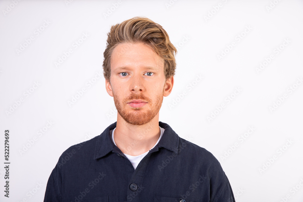 Portrait of serious young Caucasian man looking at camera. Bearded man wearing T-shirt and black shirt standing with confident expression. Successful man concept Portrait of serious young Caucasian man looking at camera. Bearded man wearing T-shirt and black shirt standing with confident expression. Successful man concept