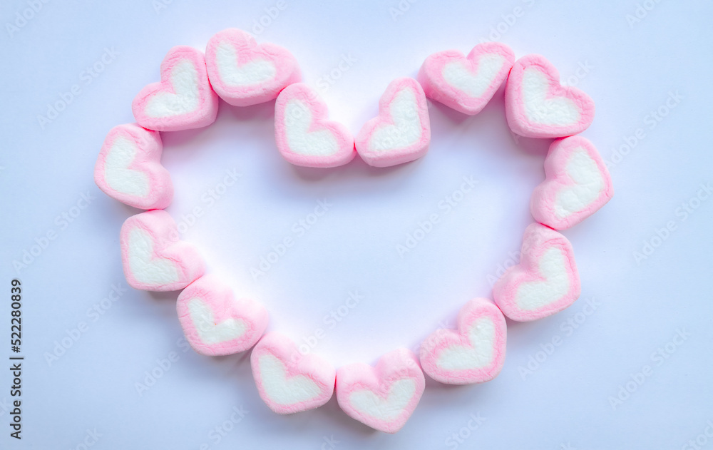 Rows of pink and white heart shaped marshmallow candies. Marshmallows in the shape of a heart on background. Fill heart for full of love , small hearts lined up to form a large heart.