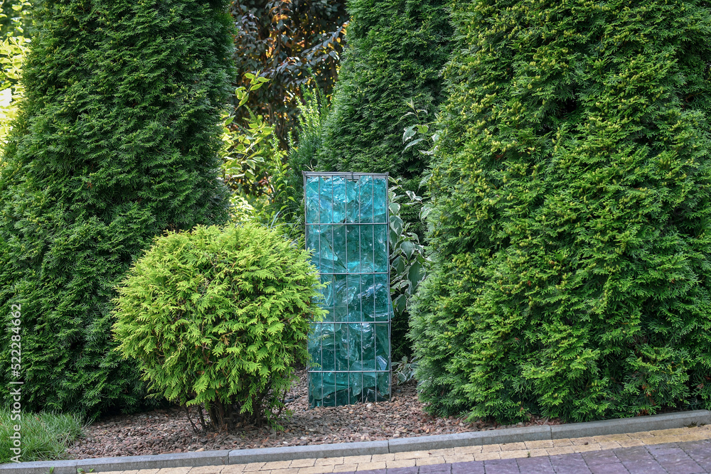 Close-up detail of gabion with metal cage filled by shattered artificial blue glass rocks. Creative modern garden decoration Close-up detail of gabion with metal cage filled by shattered artificial blue glass rocks. Creative modern garden decoration