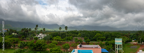 Panorama View of Rural Village Landscape in India. Western Ghat Mountains with Dark Rainy Clouds on Panoramic View.