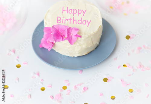 Very beautiful small white bento cake, decorated with fresh flowers of pink hydrangeas. Happy birthday lettering.