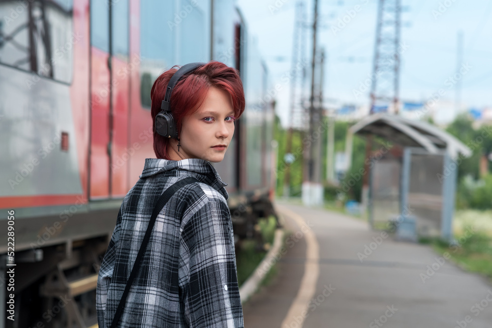 teenage girl with headphones at commuter train station teenage girl with headphones at commuter train station
