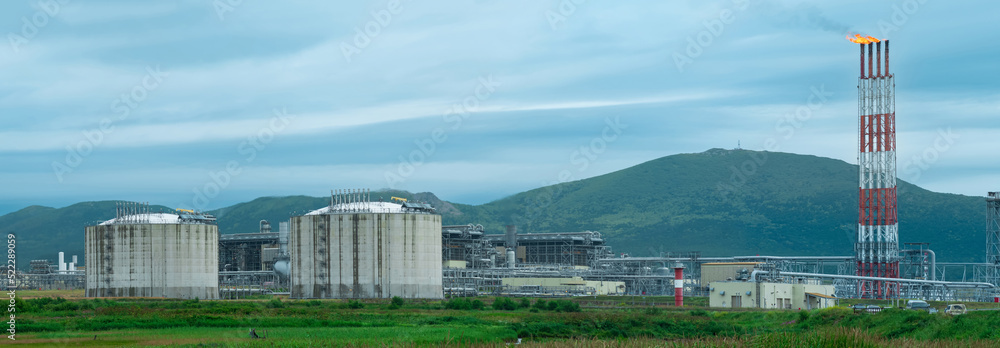 plant for the production of liquefied natural gas in a natural area against the backdrop of mountains