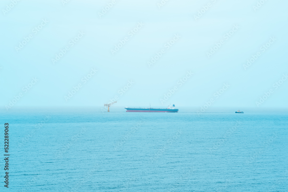 foggy seascape with a tanker near an oil terminal located far out to sea foggy seascape with a tanker near an oil terminal located far out to sea