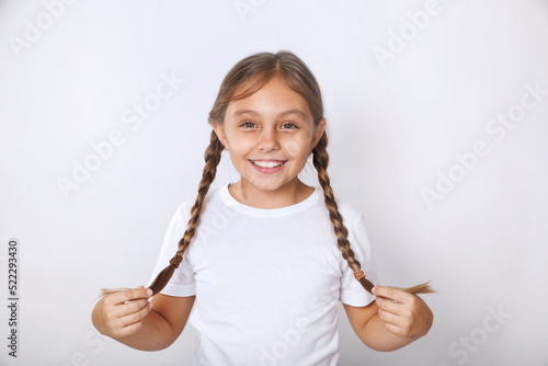 Portrait of nice funny cheerful positive pre-teen girl wearing white t-shirt having fun on white background