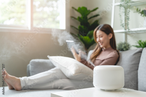Air Humidifier Device At home and Woman relaxing on the sofa photo