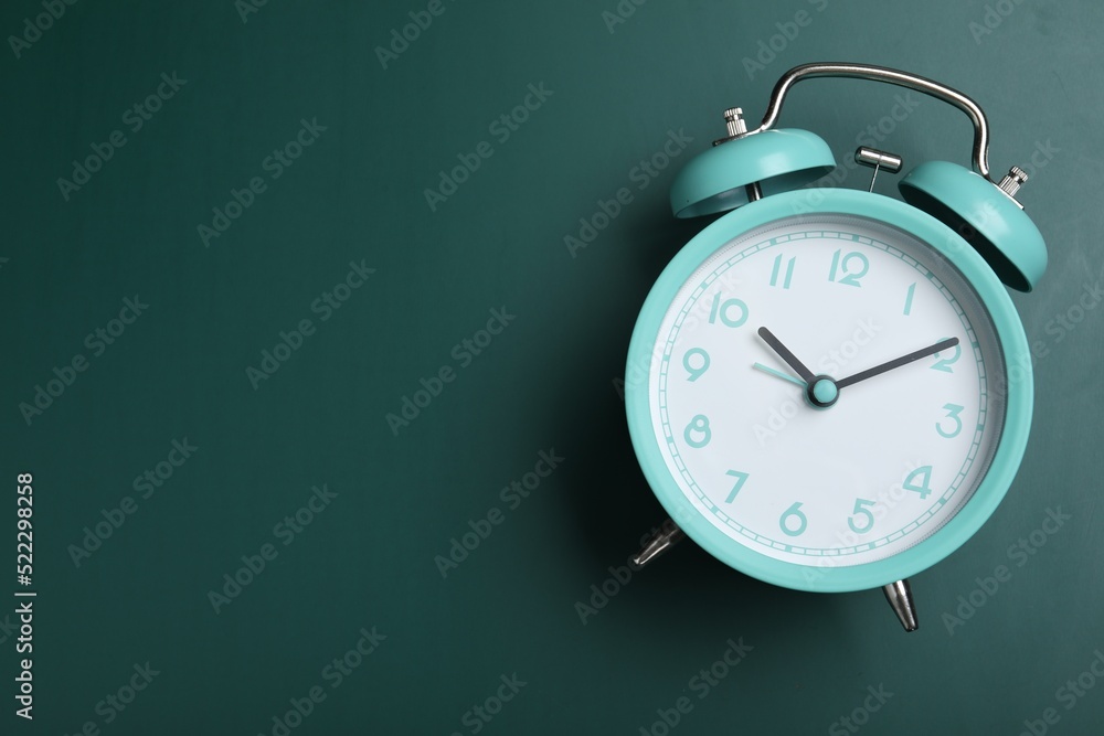 Alarm clock on green chalkboard, top view with space for text. School time Alarm clock on green chalkboard, top view with space for text. School time