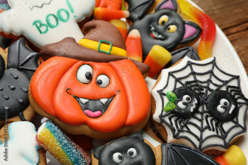 Tasty cookies and sweets for Halloween party on plate, closeup view