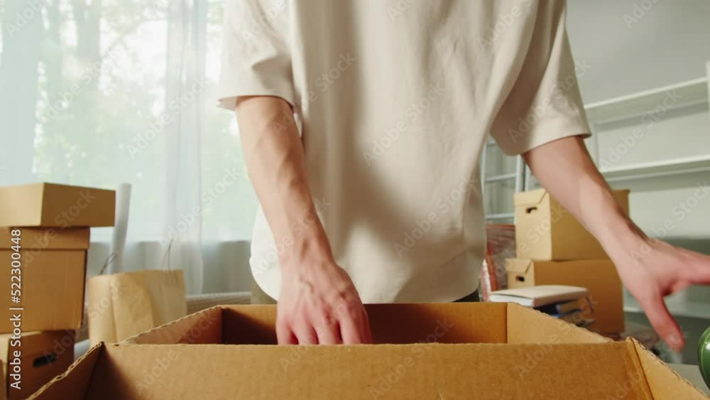 Moving to new house. Real estate, buying flat apartment. Young man unpacking cardboard boxes, guy owner during relocation. Property purchasing. Housing service concept. Moving to new house. Real estate, buying flat apartment. Young man unpacking cardboard boxes, guy owner during relocation. Property purchasing. Housing service concept.