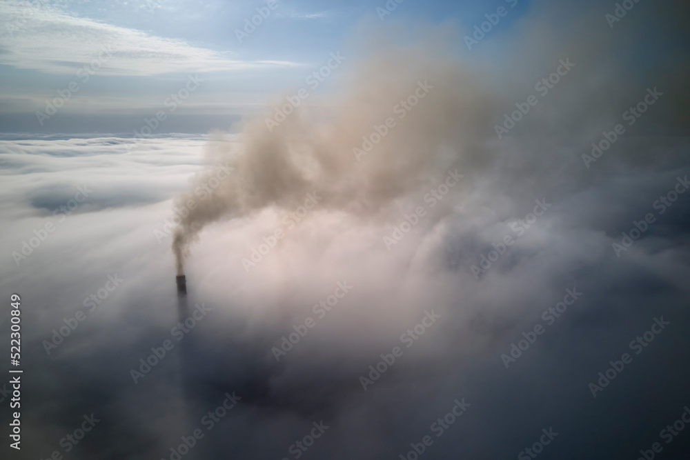 Fototapeta premium Coal power plant high pipes with black smoke moving upwards over clouds polluting atmosphere. Production of electrical energy with fossil fuel concept