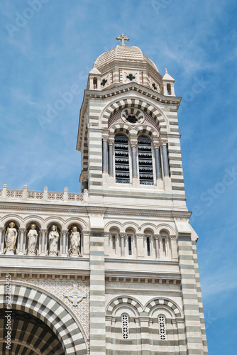 Right tower of the Marseille Cathedral in front of a blue summer sky. Sumer vacation sightseeing. Old, beautiful, romanesque-style cathedral in Marseille, France. Sightseeing in southern France. 