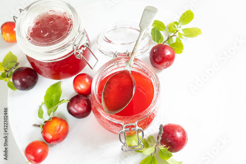 Red plum jam in a glass jar