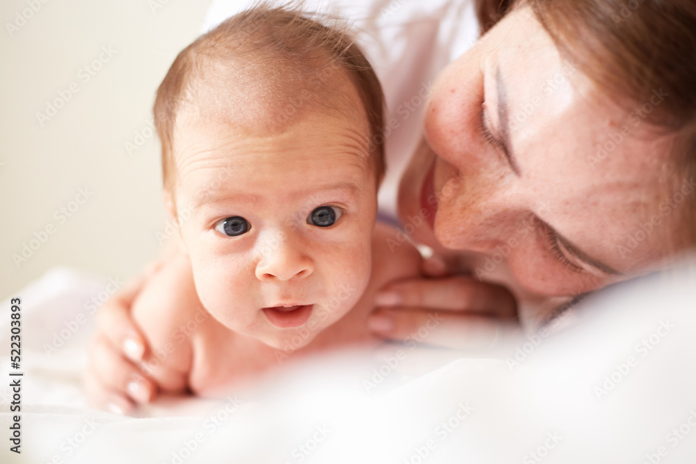 Happy mother and her newborn one month old baby boy. smiling baby Happy mother and her newborn one month old baby boy. smiling baby