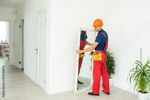 Man installing a mirror on wall