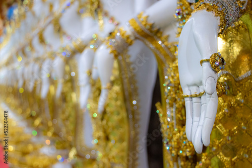 Close-up view of hand gesture of oriental statues of deities in a Buddhist temple photo