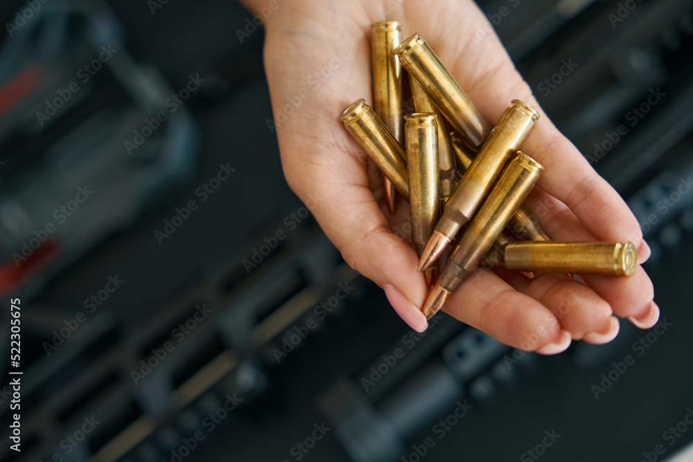 Obraz premium Combat cartridges on a tender female palm