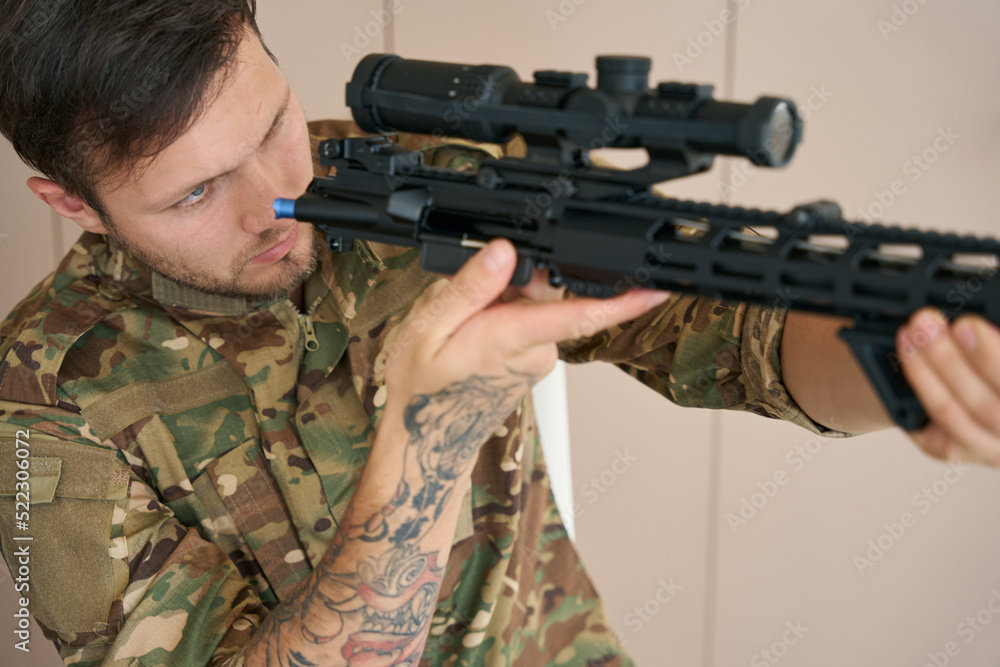 Infantryman inspects and checks his combat firearm Infantryman inspects and checks his combat firearm