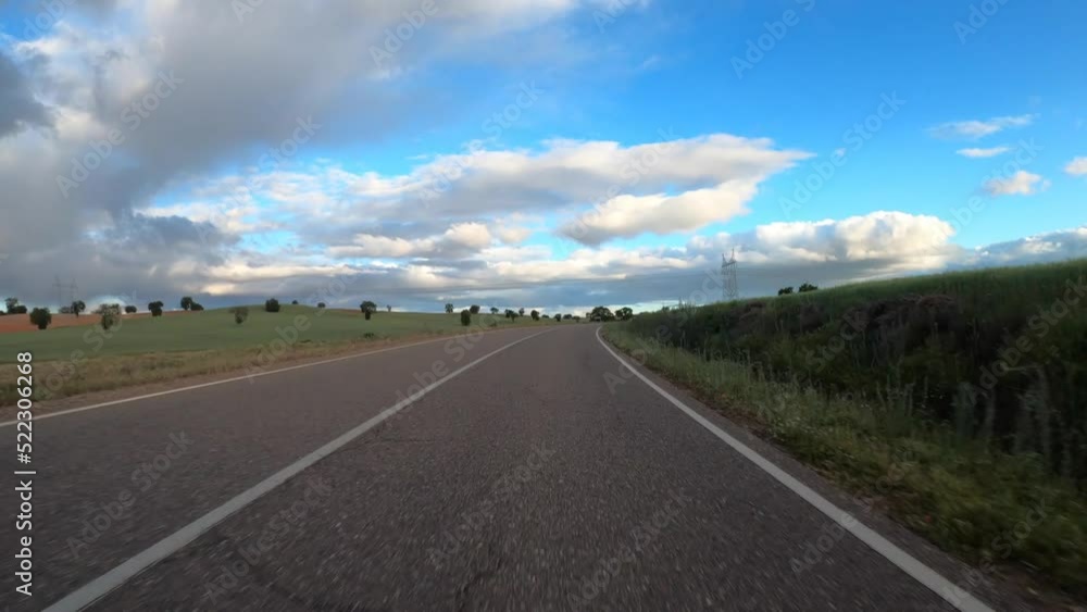 Timelapse driving a car on empty regional road through the fields outside the city during sunny day in Spain. Countryside asphalt road landscape scene. Traveling concept Timelapse driving a car on empty regional road through the fields outside the city during sunny day in Spain. Countryside asphalt road landscape scene. Traveling concept